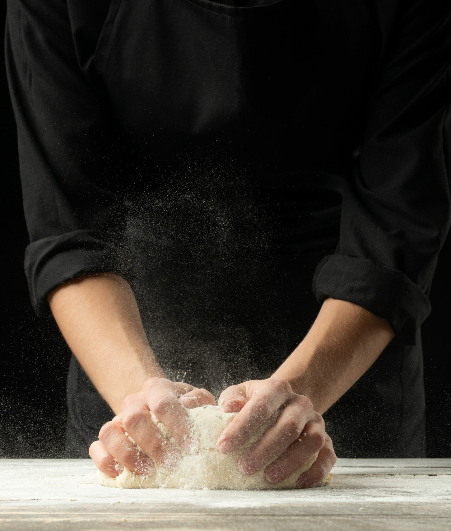 Cook baker prepares bread, focaccia, pizza, buns, sweets. Horizontal photo. Bakery concept, cooking flour products. Design for text.